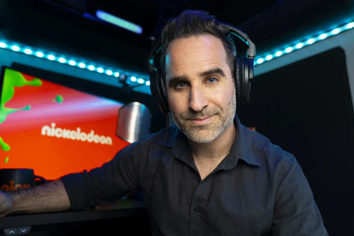 Ben in a recording booth at Nickelodeon, headphones on.