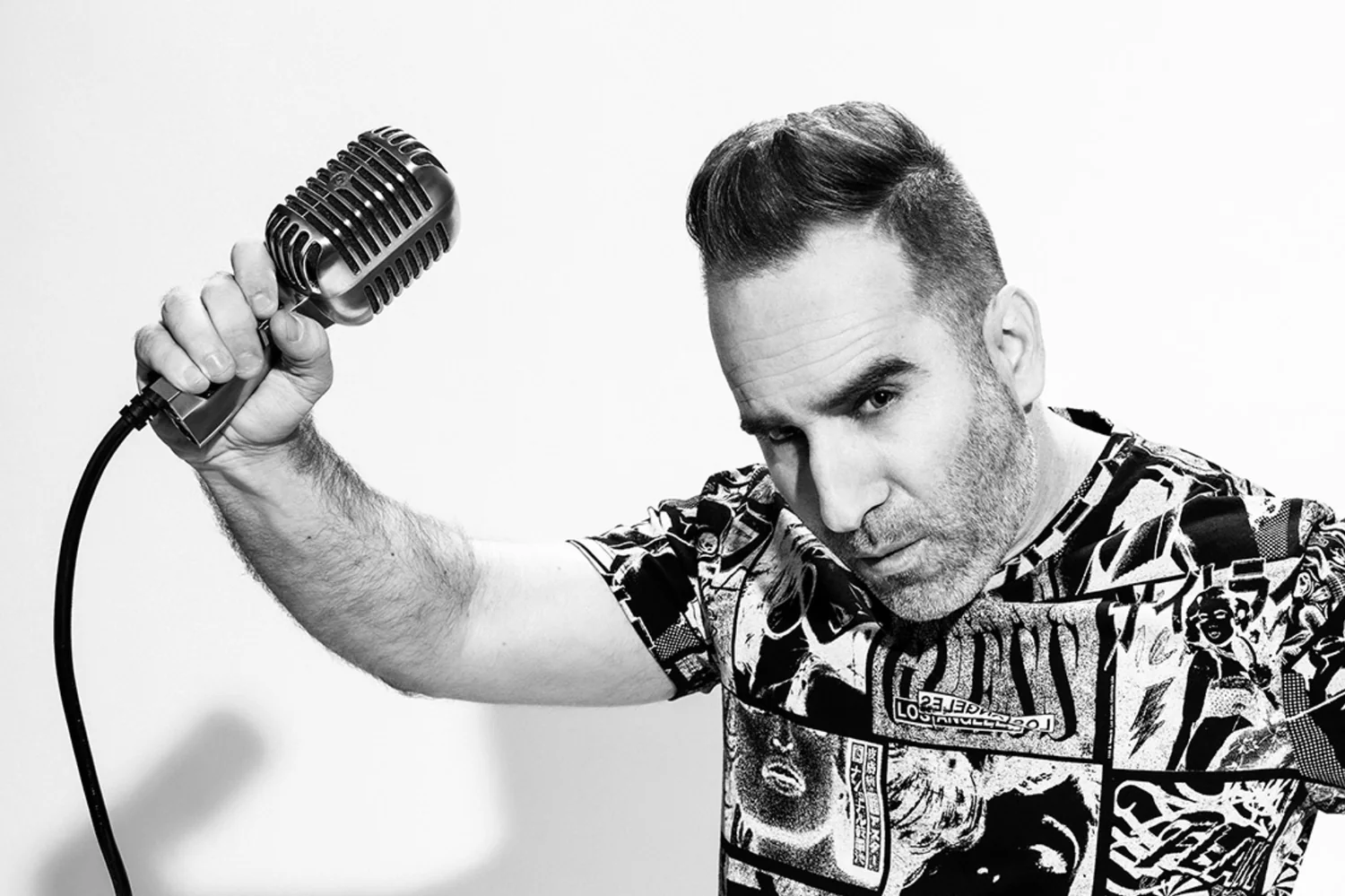 Black-and-white portrait of Ben holding a vintage microphone.